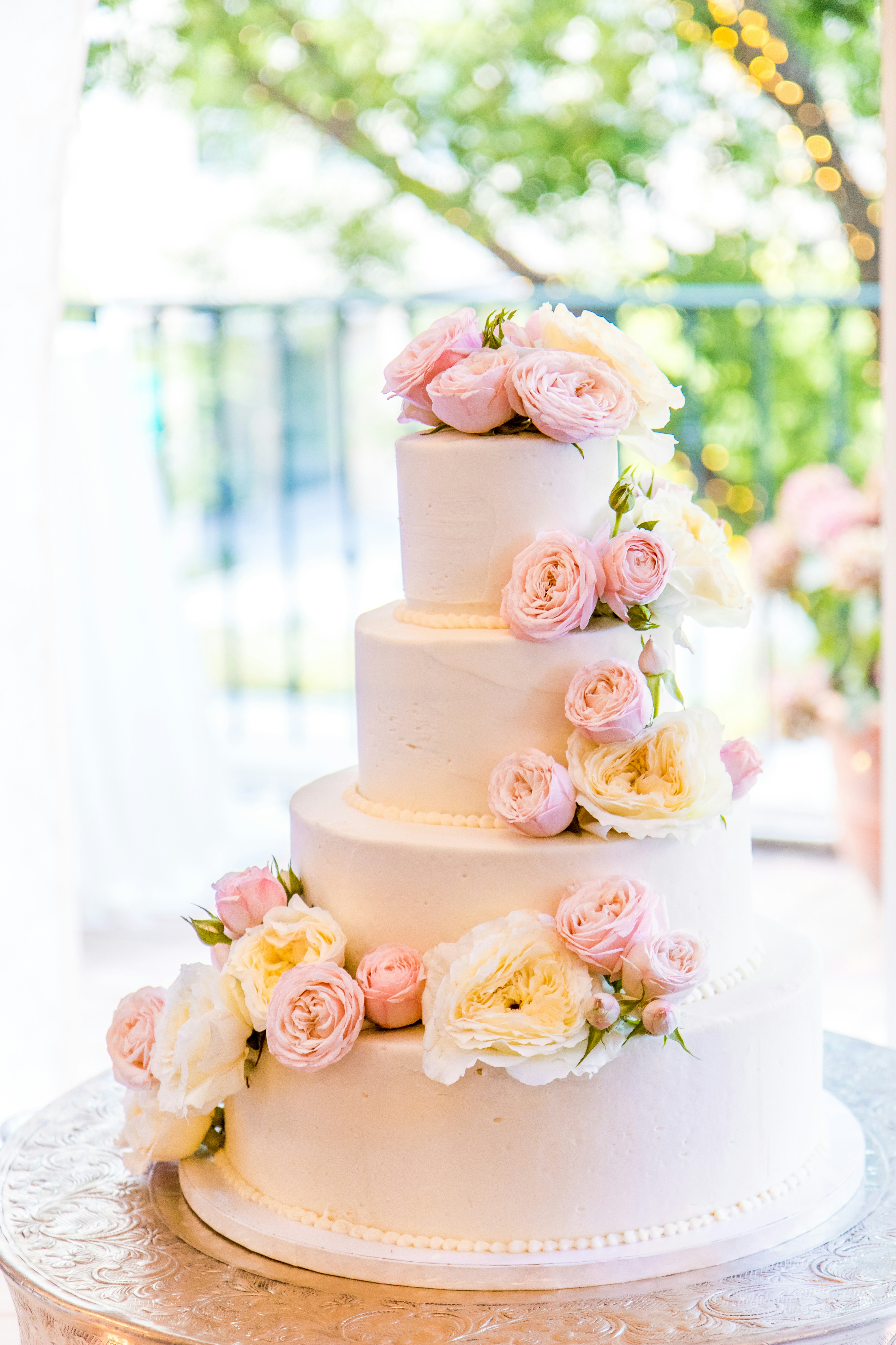 4 tier white wedding cake with pink and white flowers